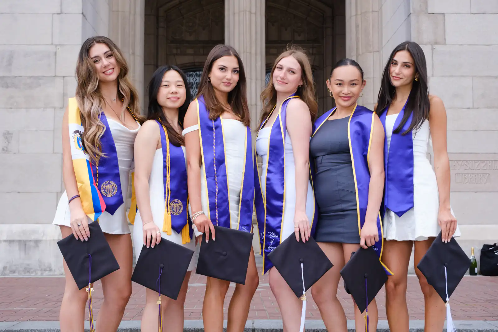 Graduates posing for a picture with their regalia